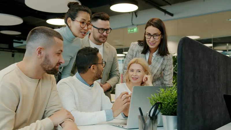 People discussing information together at a laptop.